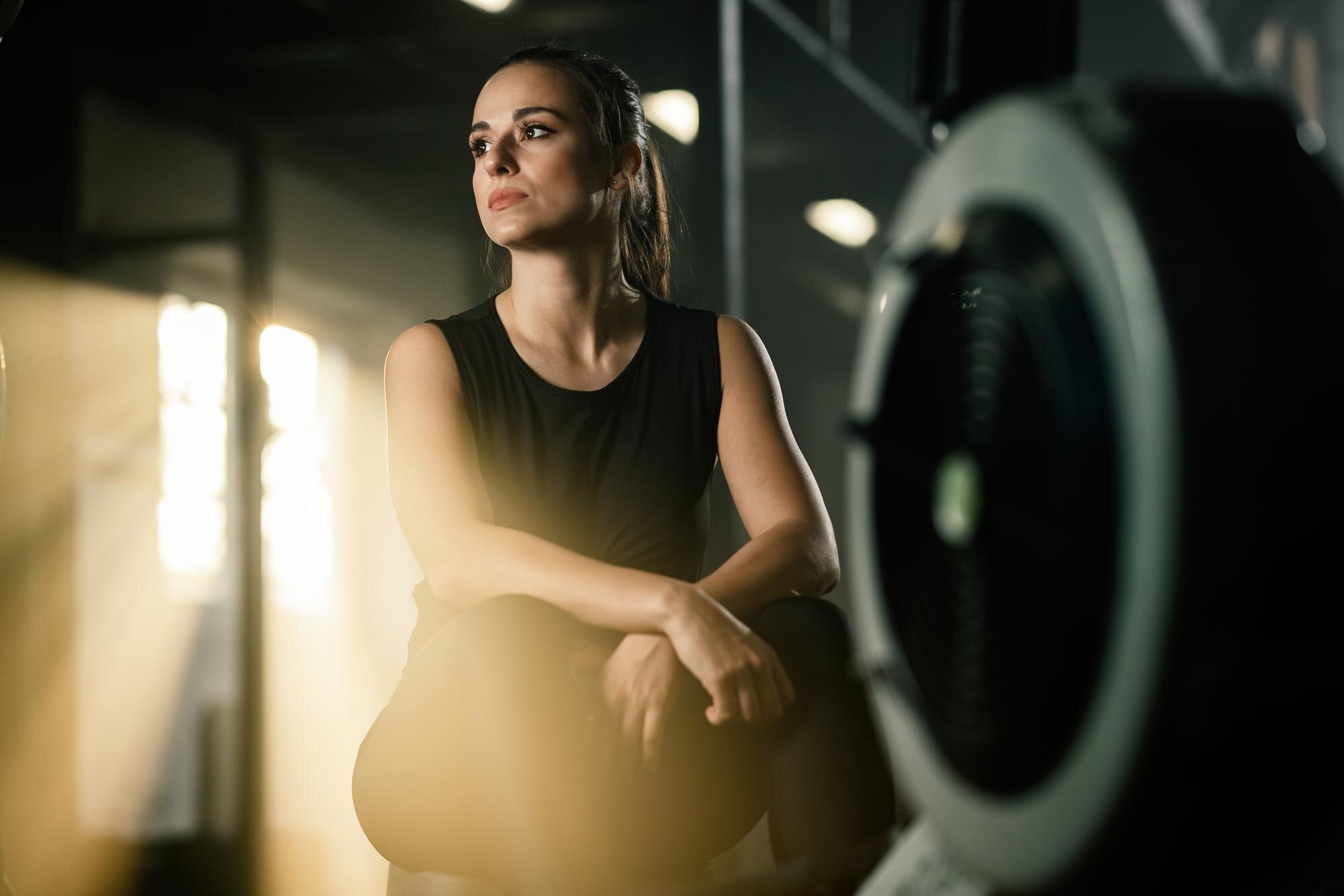 Mujer realizando ejercicio de bajo impacto en gimnasio iluminado